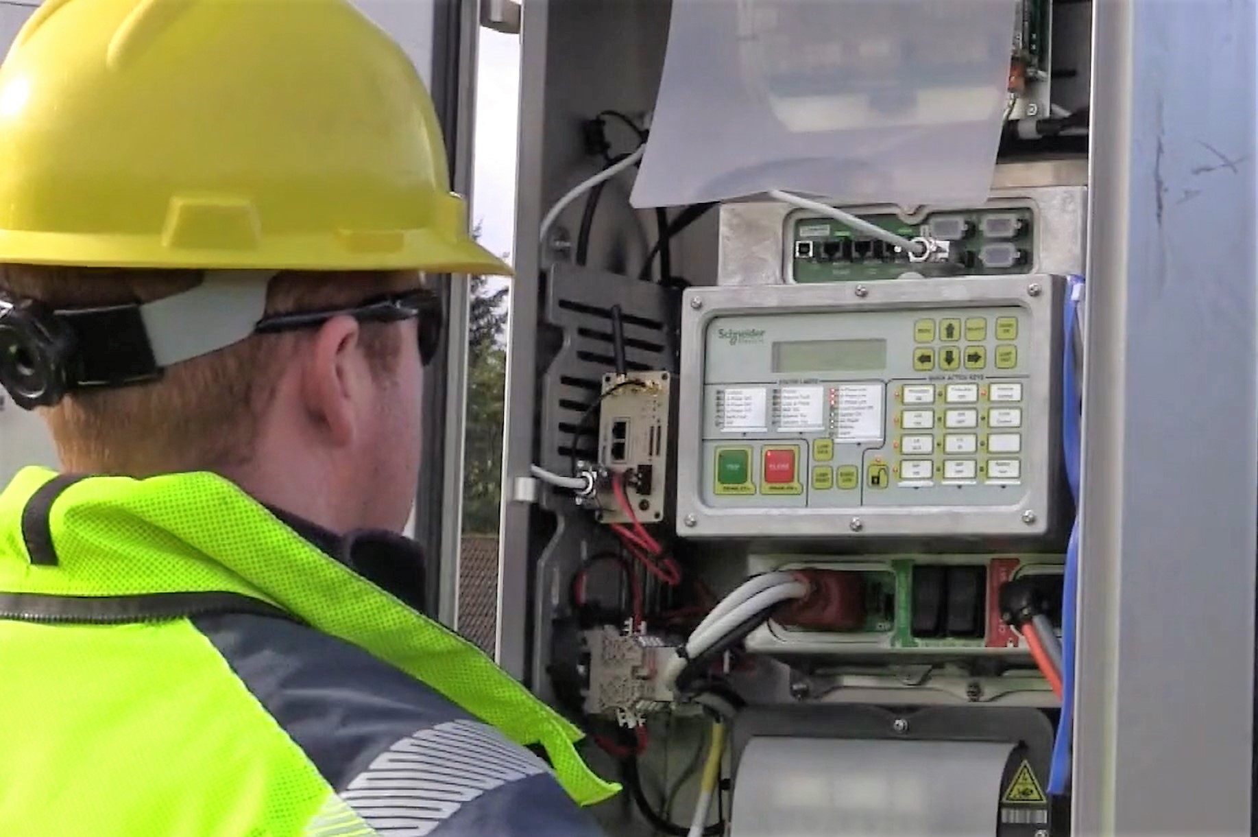 Engineer in high vis in front of switchboard