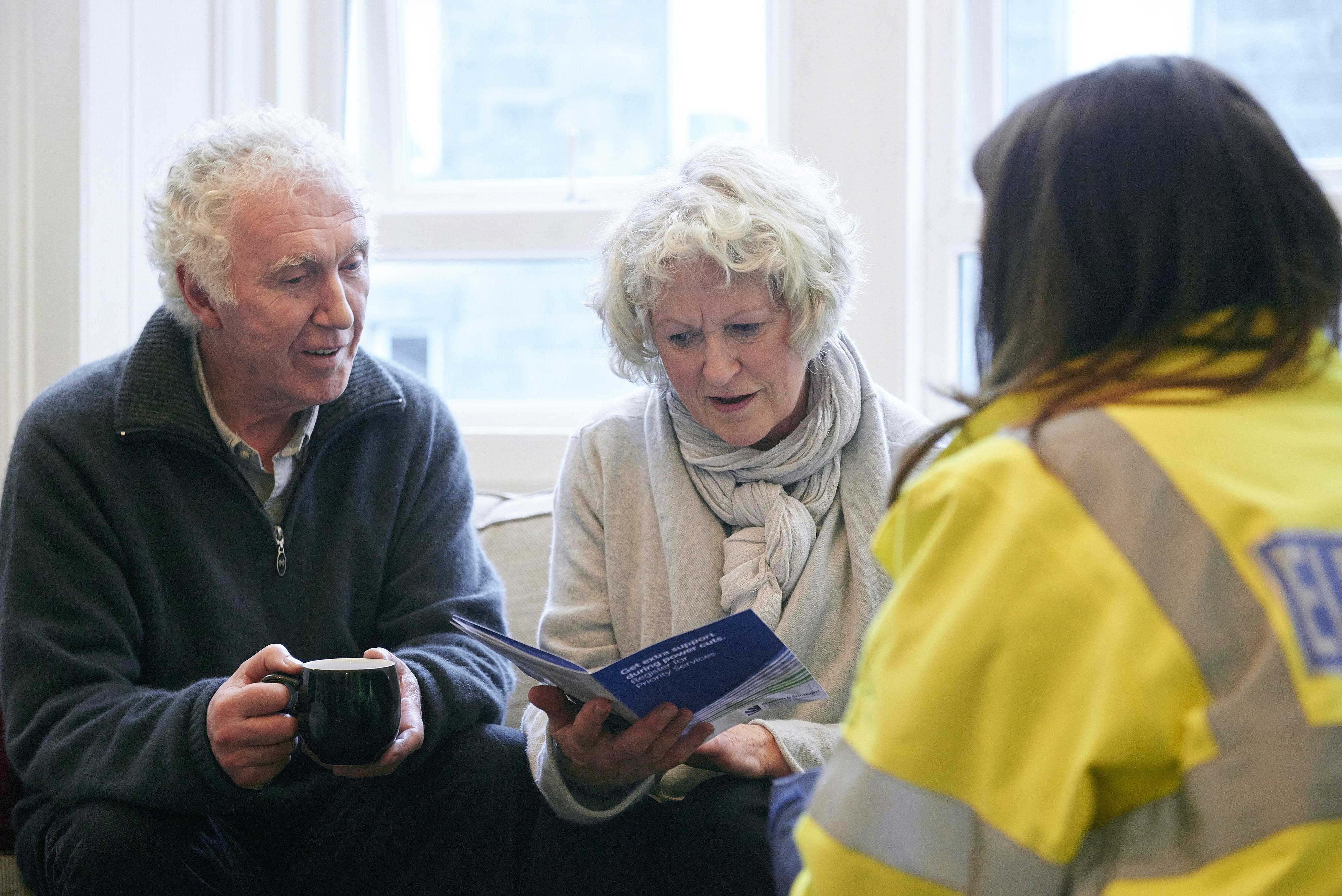 Elderly couple with woman in highvis