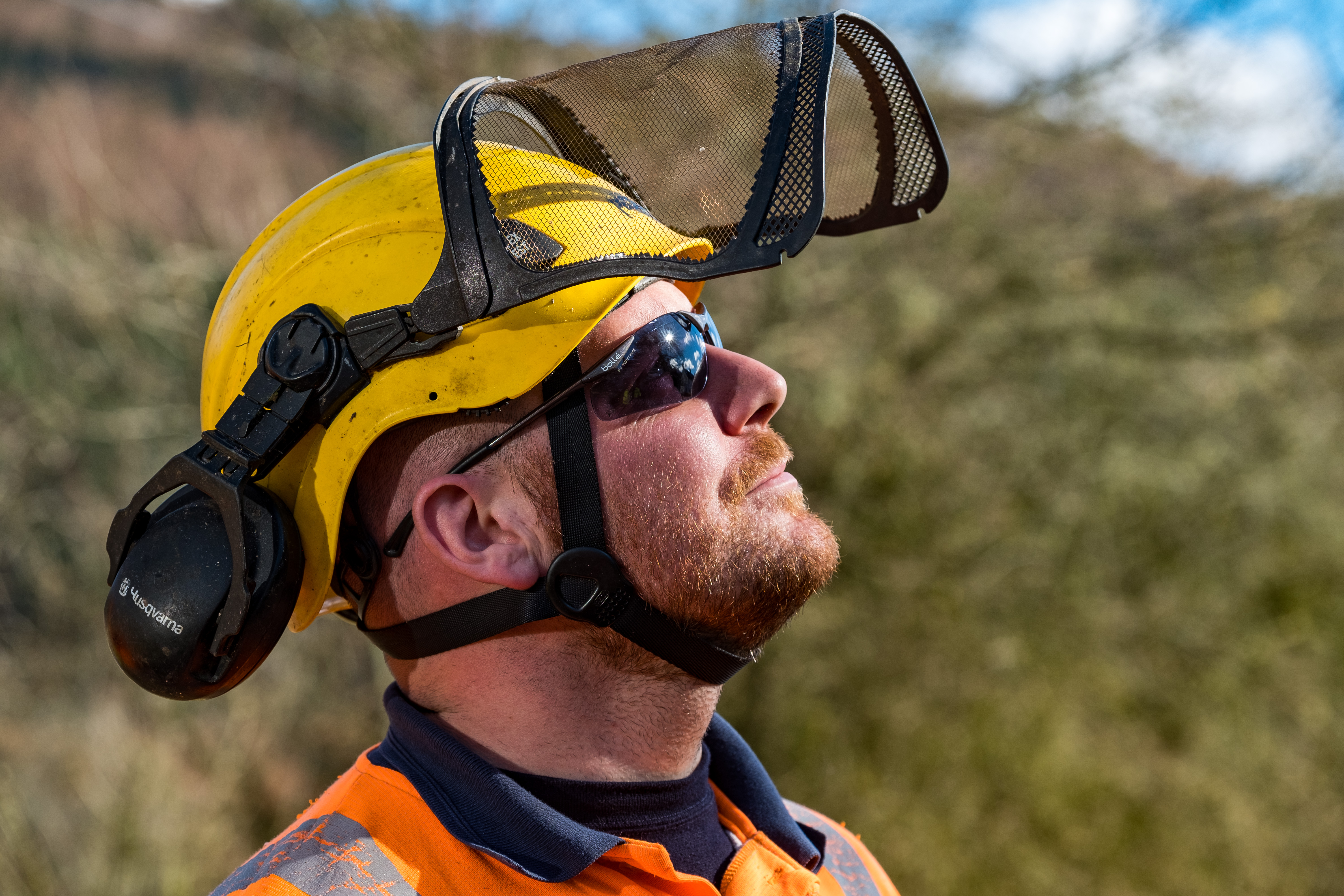 Man in hard hat and visor looking at sunny sky