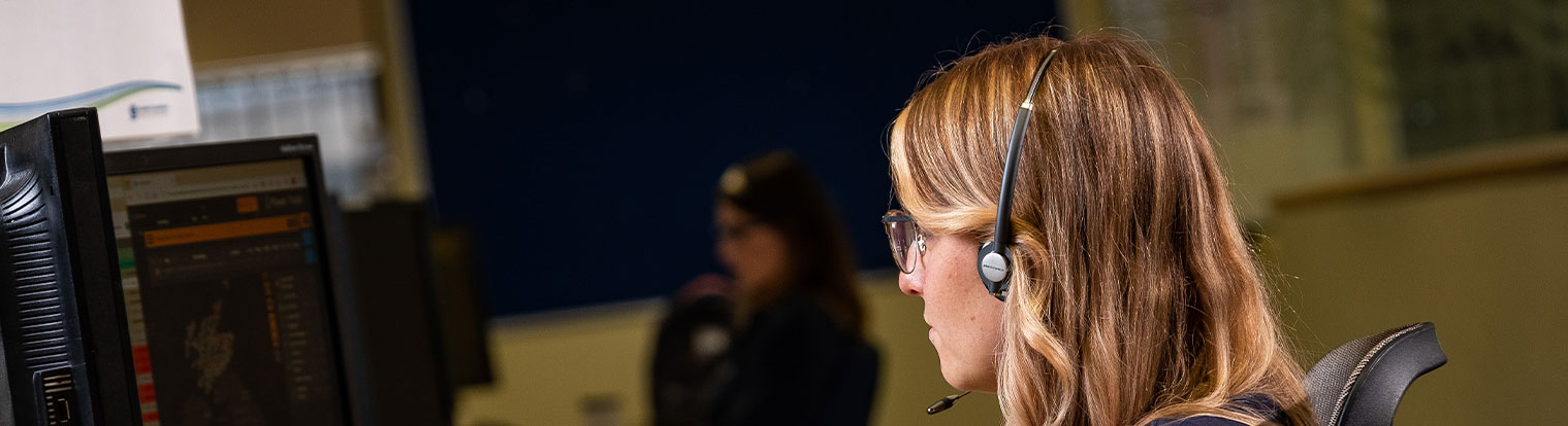 ssen advisor sitting at desk with headset on looking at screen